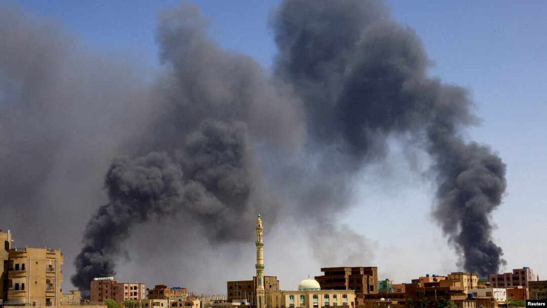FILE: A man walks while smoke rises above buildings after aerial bombardment, during clashes between the paramilitary Rapid Support Forces and the army in Khartoum North, Sudan, May 1, 2023. 