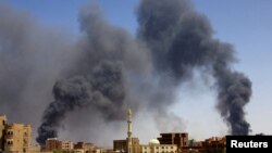 FILE: A man walks while smoke rises above buildings after aerial bombardment, during clashes between the paramilitary Rapid Support Forces and the army in Khartoum North, Sudan, May 1, 2023. 