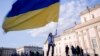 (FILE) A woman waves a Ukrainian flag as she attends a protest in Germany.