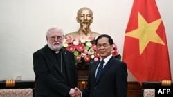 Menteri Luar Negeri Vietnam Bui Thanh Son (kanan) berjabat tangan dengan Menteri Hubungan Vatikan Uskup Agung Paul Gallagher (kiri) di Kementerian Luar Negeri di Hanoi, 9 April 2024. (Nhac NGUYEN / POOL / AFP)