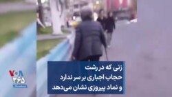 زنی که در رشت حجاب اجباری بر سر ندارد و نماد پیروزی نشان می‌دهد