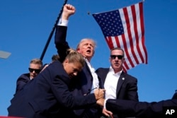 FILE - Republican presidential candidate Donald Trump is surrounded by U.S. Secret Service agents following an assassination attempt at a campaign rally, in Butler, Pa., July 13, 2024.