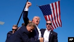 FILE - Republican presidential candidate former president Donald Trump is surrounded by U.S. Secret Service agents following an assassination attempt at a campaign rally, in Butler, Pennsylvania, July 13, 2024.