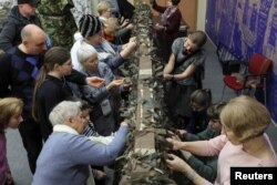 Los visitantes asisten a una clase sobre redes de camuflaje en un festival de temática patriótica, el día del Defensor de la Patria en San Petersburgo, Rusia, el 23 de febrero de 2024. Foto: Reuters