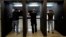 FILE - Gun owners fire their pistols at an indoor shooting range during a qualification course to renew their carry concealed handgun permits, at the Placer Sporting Club in Roseville, California, July 1, 2022.