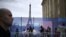 Pengunjung berjalan melewati pembatas di Trocadero dengan latar belakang Menara Eiffel di Paris, 16 Juli 2024. (JULIEN DE ROSA / AFP)