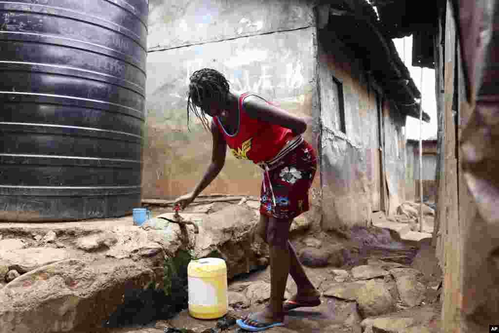 Una mujer llena un balde con agua del tanque de un vendedor en una barriada de Nairobi, en Kenia.&nbsp;