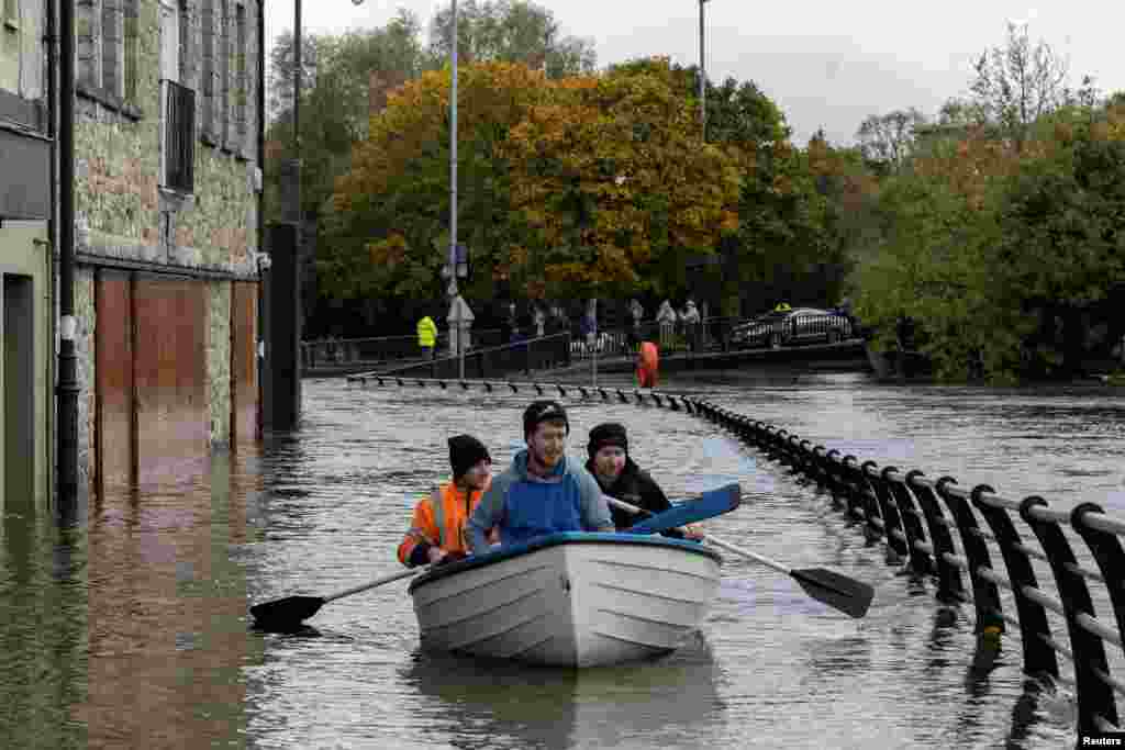 People row a boat through water after heavy rain caused extensive floodin, ahead of the arrival of Storm Ciaran, in the city center of Newry, Northern Ireland.
