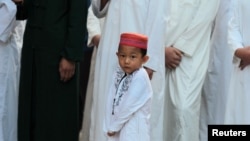 资料照：中国云南省寻甸回族彝族自治县的一座清真寺内一个小男孩参加古尔邦节的晨祷。（2019年8月12日）