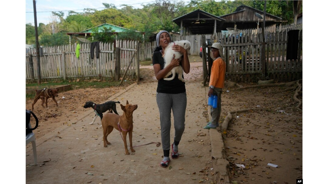 Venezuelan migrant Johany “Flaca” Rodriguez carries her dog Kiko at a shelter in Assis, Brazil, June 20, 2024.