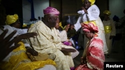 FILE - Sunlola Ogungbadero kneels to receive blessings from her parents during her traditional wedding in Surulere district in Lagos, Nigeria, July 31, 2014.
