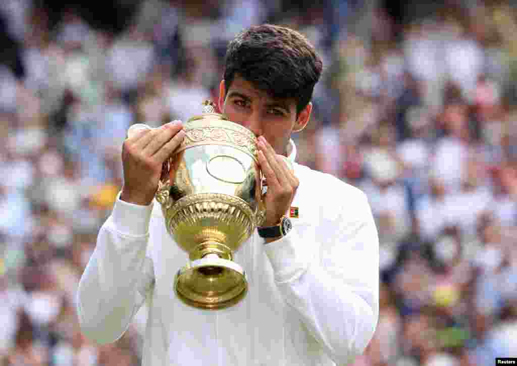 Petenis Carlos Alcaraz dari Spanyol berpose dengan trofi setelah memenangi final tunggal putra melawan Novak Djokovic dari Serbia pada kejuaraan tenis grand slam Wimbledon di London. (Reuters)&nbsp;