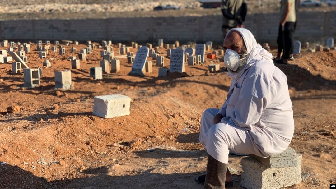 A man sits by the graves of flash-flood victims in Derna, Libya, Sept. 15, 2023. A Libyan Red Crescent official said more than 10,000 people were reported missing in the city. Health authorities previously put the death toll in Derna at 5,500.