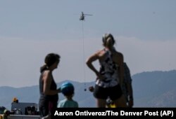 Onlookers watch while crews work near the Ken Caryl Ranch development as the Quarry fire burns southwest of Littleton, Colorado, Aug. 1, 2024. (Aaron Ontiveroz/The Denver Post via AP)