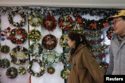 Orang-orang berjalan melewati dekorasi Natal di sebuah mal di Beijing, China, 14 Desember 2023. (Foto: REUTERS/Tingshu Wang)