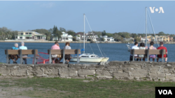 People sit by the water in St. Augustine, Florida, March 1, 2023. 