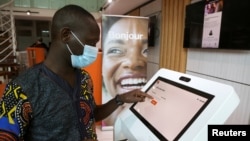 FILE - A man performs a financial transaction at Orange, a French mobile operator based in Abijan, Ivory Coast, September 18, 2020