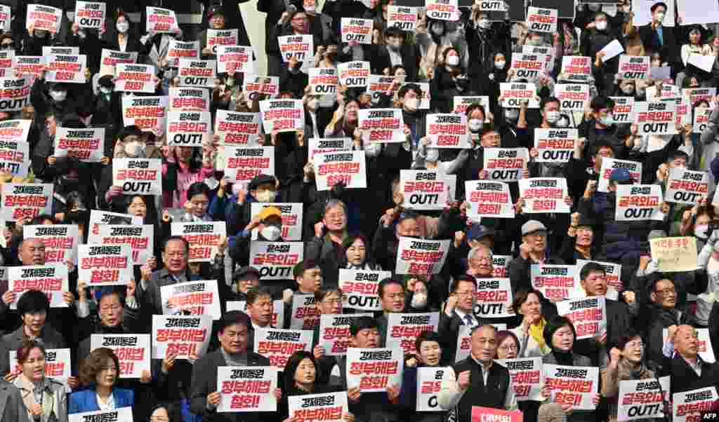 South Korean lawmakers and protesters hold placards during an anti-government rally denouncing South Korea's plans to compensate victims of Japan's forced wartime labor, at the National Assembly in Seoul.