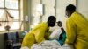 FILE - Nurses attend to a patient lying on a hospital bed in a medical ward at a local hospital in Harare, Zimbabwe, April 26, 2022.