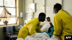 FILE - Nurses attend to a patient lying on a hospital bed in a medical ward at a local hospital in Harare, Zimbabwe, April 26, 2022.