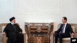 Presiden Suriah Bashar Assad (kanan), bertemu dengan Presiden Iran Ebrahim Raisi di istana kepresidenan di Damaskus, Suriah, Rabu, 3 Mei 2023. (Kepresidenan Suriah via Facebook via AP )