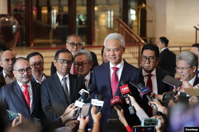 Pasangan capres-cawapres Ganjar Pranowo dan Mahfud MD hari Senin (22/4) bicara pada wartawan sesaat sebelum berangkat ke Mahkamah Konstitusi untuk mendengar putusan atas gugatan mereka. (Courtesy: TPN Ganjar-Mahfud)