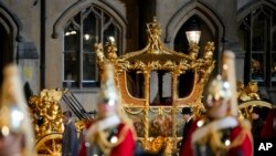 The Gold State Coach is led in a procession as it leaves Westminster Abbey in central London, May 3, 2023 during a rehearsal for the Coronation of King Charles III.