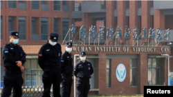 Para petugas keamanan berjaga di depan Institut Virologi Wuhan di Wuhan, Hubei, China, ketika sejumlah anggota WHO mengunjungi lembaga tersebut pada 3 Februari 2021. (Foto: Reuters/Thomas Peter)