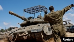 An Israeli soldier directs a tank near the Israel-Gaza border in Israel, April 10, 2024.