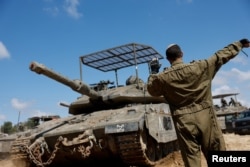 Seorang tentara Israel mengarahkan tank di dekat perbatasan Israel-Gaza, di tengah konflik yang sedang berlangsung antara Israel dan kelompok Islam Palestina Hamas, di Israel, 10 April 2024. (REUTERS/Amir Cohen)