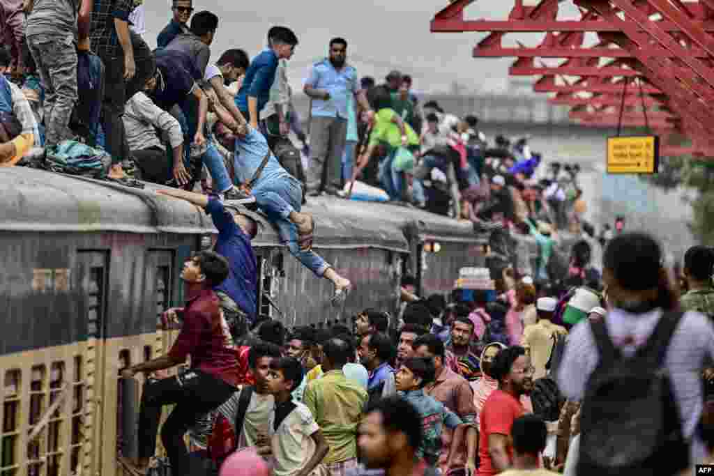 People board a train at the Tongi railway station in Tongi on the outskirts of Dhaka, as they travel back home ahead of Eid al-Adha, the feast of the sacrifice marking the end of the Hajj pilgrimage to Mecca. 
