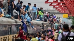 People board a train at the Tongi railway station in Tongi on the outskirts of Dhaka, as they travel back home ahead of Eid al-Adha, the feast of the sacrifice marking the end of the Hajj pilgrimage to Mecca. (Photo by MUNIR UZ ZAMAN / AFP)
