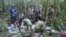 In this photo released by Colombia's Armed Forces Press Office, soldiers and Indigenous men tend to the four Indigenous children who were missing after a deadly plane crash, in the Solano jungle, Caqueta state, Colombia, June 9, 2023.