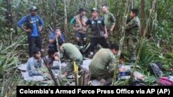 Sejumlah tentara dan penduduk pribumi merawat empat anak yang hilang setelah kecelakaan pesawat di hutan Solano, negara bagian Caqueta, Kolombia, Jumat, 9 Juni 2023. (Kantor Pers Angkatan Bersenjata Kolombia via AP)