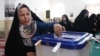 An Iranian woman casts her ballot at a polling station during presidential election in Tehran on June 28, 2024.