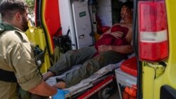 Petugas keamanan Israel di Kiryat Shoma, di utara Israel, mengevakuasi seorang pria asal Thailand yang terluka setelah terkena misil anti-tank yang ditembakan dari Lebanon, pada 4 Maret 2024. (Foto: AP/Ariel Schalit)