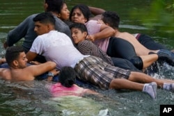 FILE - Migrants cross the Rio Grande river on an inflatable mattress to the U.S., from Matamoros, Mexico, May 9, 2023.