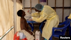 Christian Musema, a laboratory nurse, takes a sample from a child declared a suspected case mpox at the treatment center in Munigi in Nyiragongo territory near Goma, North Kivu province, Democratic Republic of the Congo, July 19, 2024. 