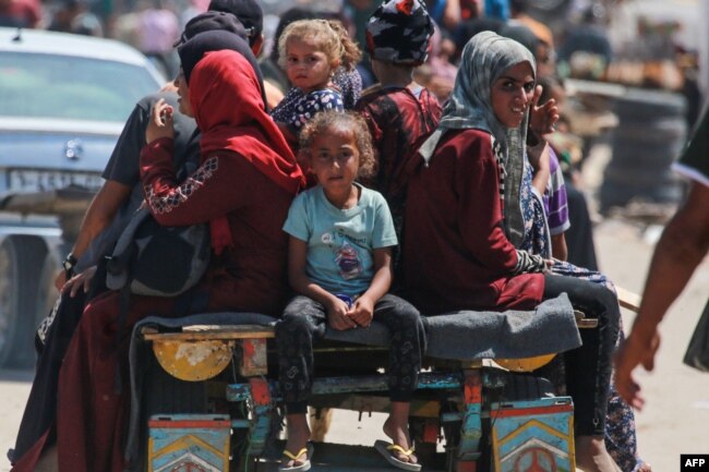 Warga Palestina menaiki gerobak yang ditarik hewan di kawasan perumahan pengungsi di Rafah, di Jalur Gaza selatan, 19 Juni 2024, di tengah konflik antara Israel dan Hamas. (Bashar TALEB / AFP)