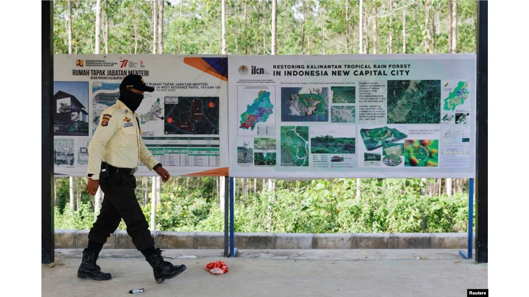 Seorang petugas keamanan berjalan melewati papan informasi di titik nol ibu kota baru, yang dikenal sebagai Ibu Kota Negara Nusantara (IKN), di Sepaku, Kalimantan Timur, 8 Maret 2023. (Foto: REUTERS/Willy Kurniawan)
