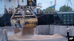 FILE - Workers load grain at a grain port in Izmail, Ukraine, on April 26, 2023.