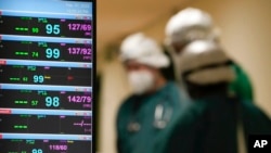 FILE - Medical workers monitor patients in the sub-intensive care ward of the Tor Vergata Hospital, in Rome, Feb. 7, 2022.