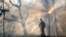 FILE -A member of the Bridge Crew watches over a fire line, Jan. 6, 2010, in case the prescribed burn jumps the line and ignites on the other side of Kings Pinnacle in Crowders Mountain State Park in Gastonia, NC. 