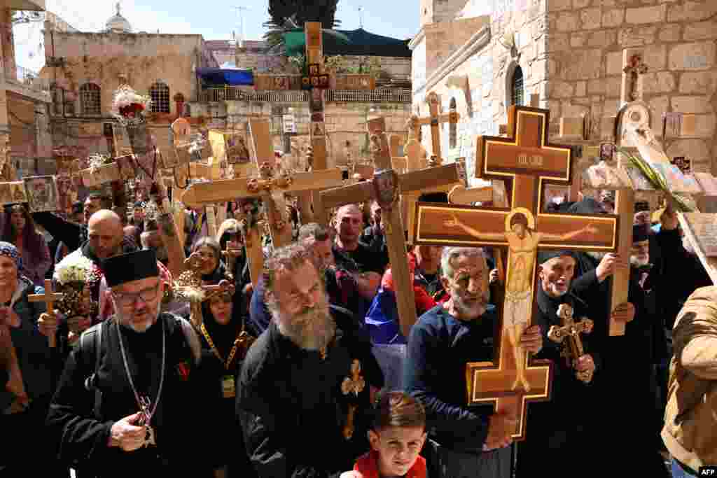 Orthodox Christian pilgrims hold wooden crosses as they gather outside the Holy Sepulchre church during the Holy Friday procession through the Via Dolorosa (Way of Suffering) in Jerusalem's Old City.