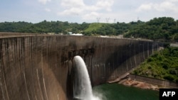 FILE: Flood gates on the Kariba Dam wall between Zimbabwe and Zambia open ceremonially on February 20, 2015 after the two neighbors signed $294 million in deals with international investors. China Energy plans a massive floating solar plant behind the dam.