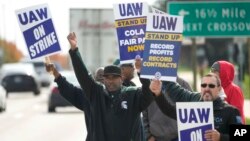 FILE - United Auto Workers members walk the picket line during a strike at the Stellantis Sterling Heights Assembly Plant, in Sterling Heights, Mich., Oct. 23, 2023. 