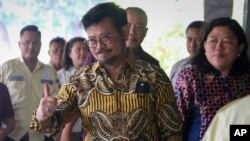 Menteri Pertanian Indonesia Syahrul Yasin Limpo memberi isyarat kepada wartawan setibanya di kantornya di Jakarta, Kamis, 5 Oktober 2023. (Foto AP)