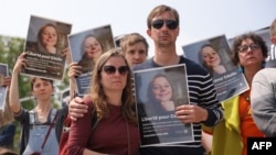 FILE - Relatives, friends and supporters hold portraits of French teacher Cecile Kohler, detained along with her partner Jacques Paris in Iran, during a rally in their support in Paris, May 14, 2023. 