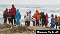Tim penyelamat menemukan mayat di pantai dekat Cutro, Italia selatan, setelah sebuah kapal migran pecah di laut yang ganas, Minggu, 26 Februari 2023. (Foto: AP/Giuseppe Pipita)