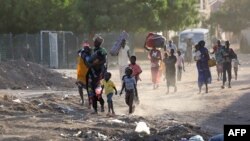 FILE: People flee their neighborhoods amid fighting between the army and paramilitaries in Khartoum on April 19, 2023, following the collapse of a 24-hour truce.
